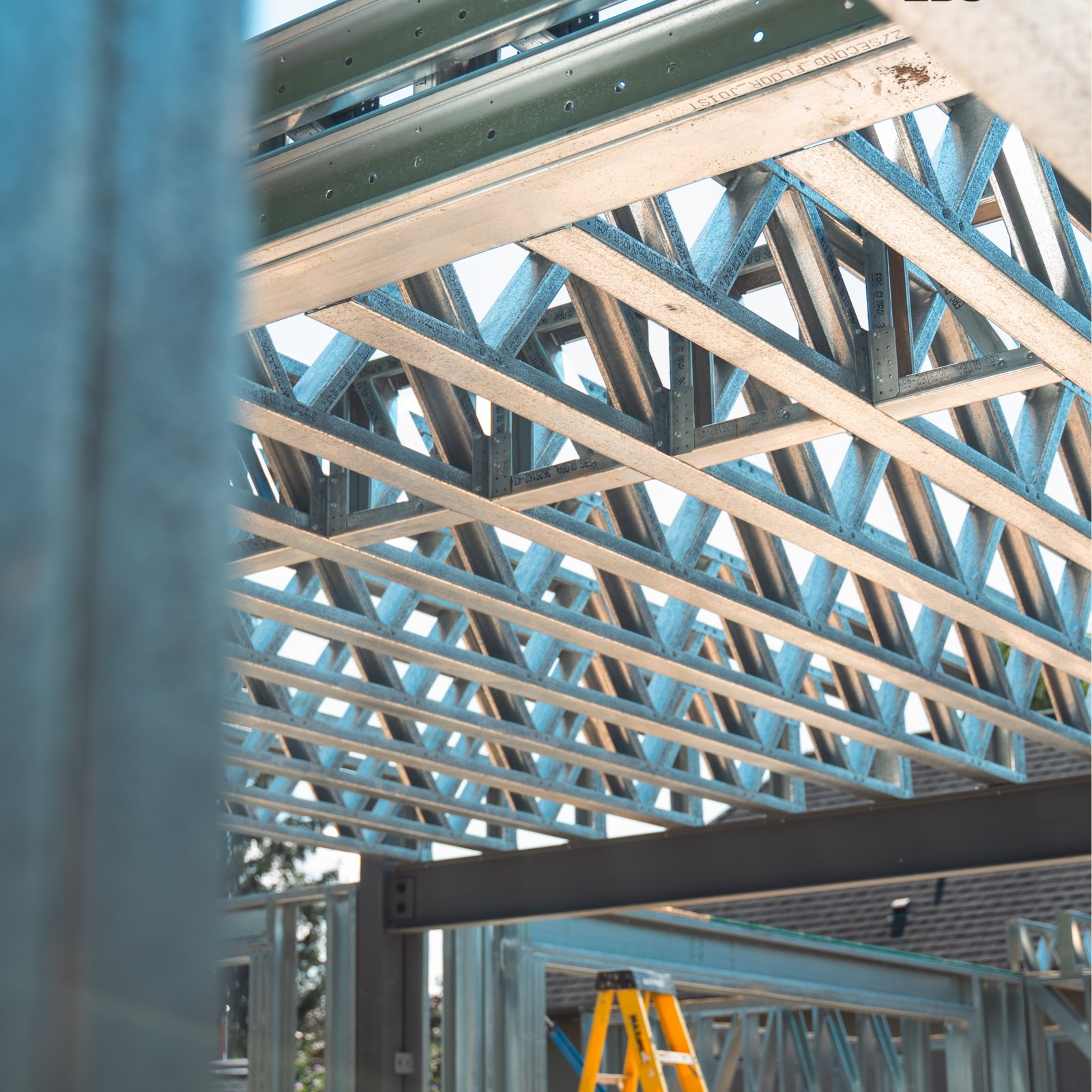 Floor trusses in place, looking up through the frame.