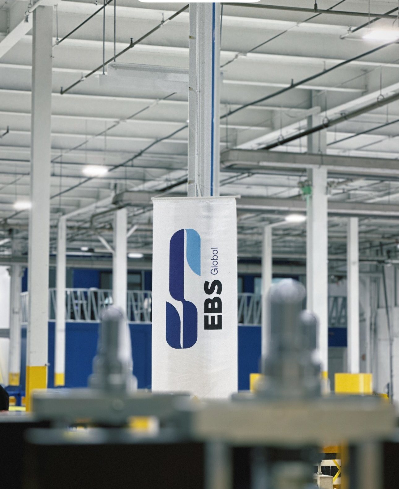 The production floor at the EBS Global plant, company banner overhead