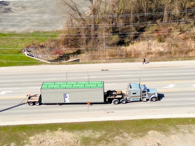 The clad modular unit on its way by truck