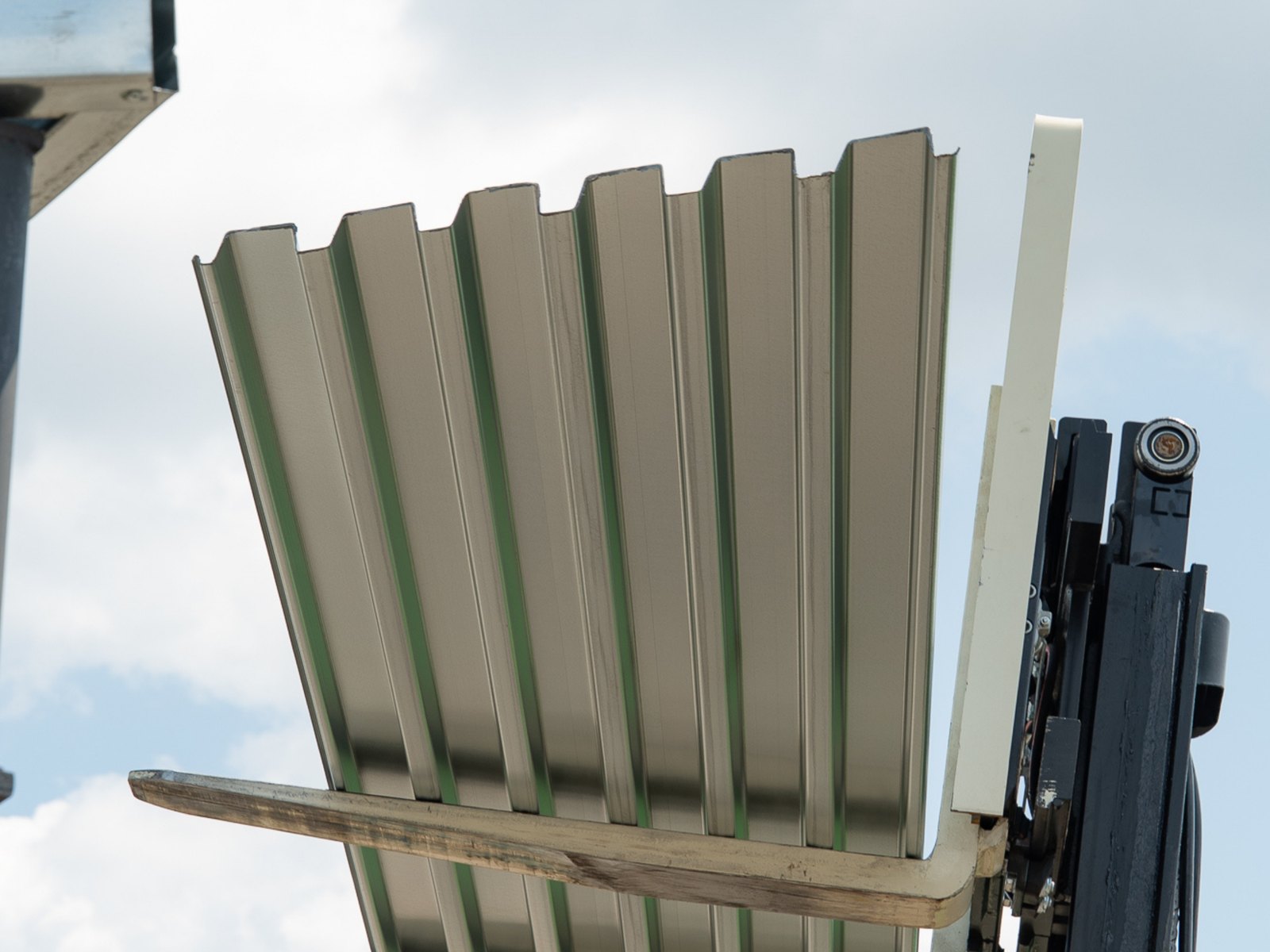 A bundle of steel deck lifted by forklift at the plant