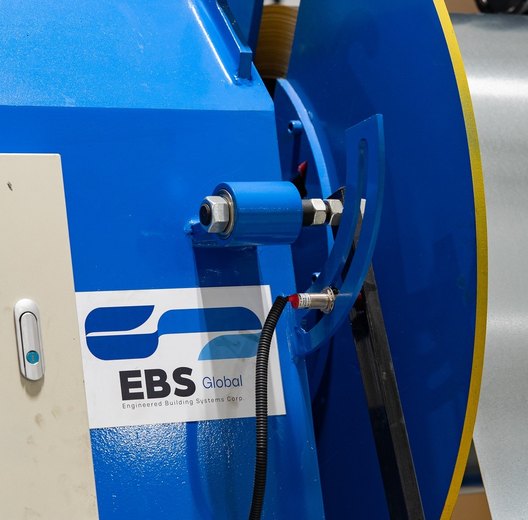 Galvanized steel coil on the decoiler with the EBS Global sticker