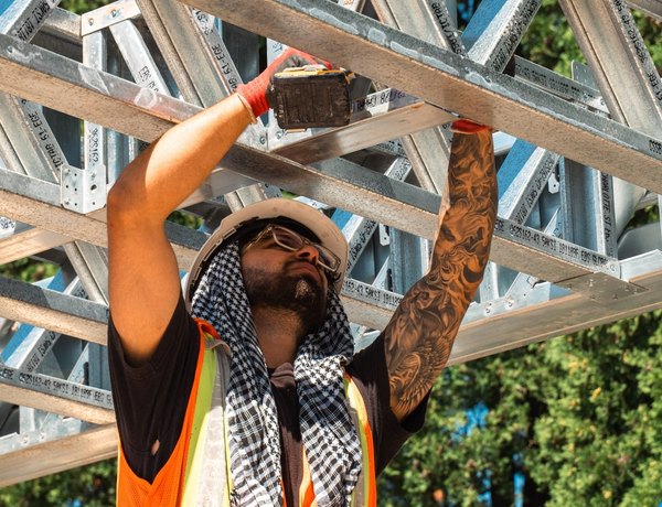 An EBS Global crew member setting a cold-formed steel truss on site