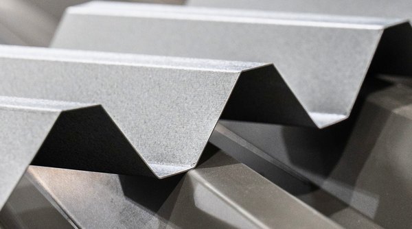 Galvanized trapezoidal deck profiles coming off the roll-former