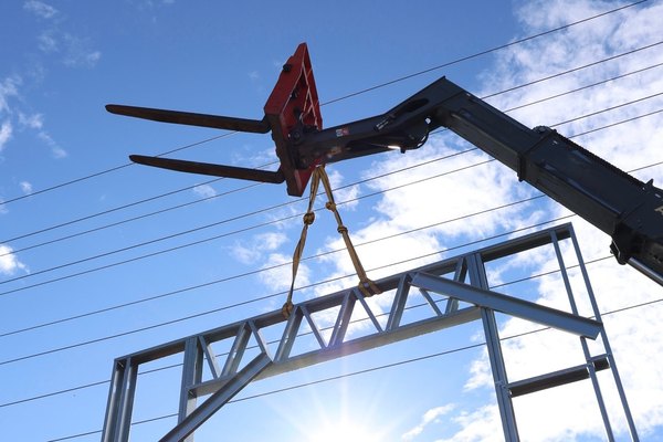 Cold-formed steel wall panel with truss header lifted on straps