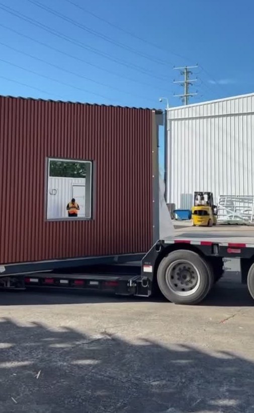 Orange-clad modular classroom unit on a trailer outside the EBS plant